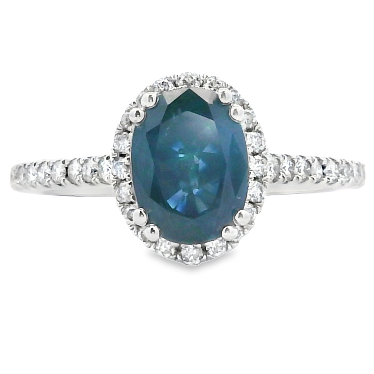 Ring with a blue gemstone and diamond-studded halo on a white background
