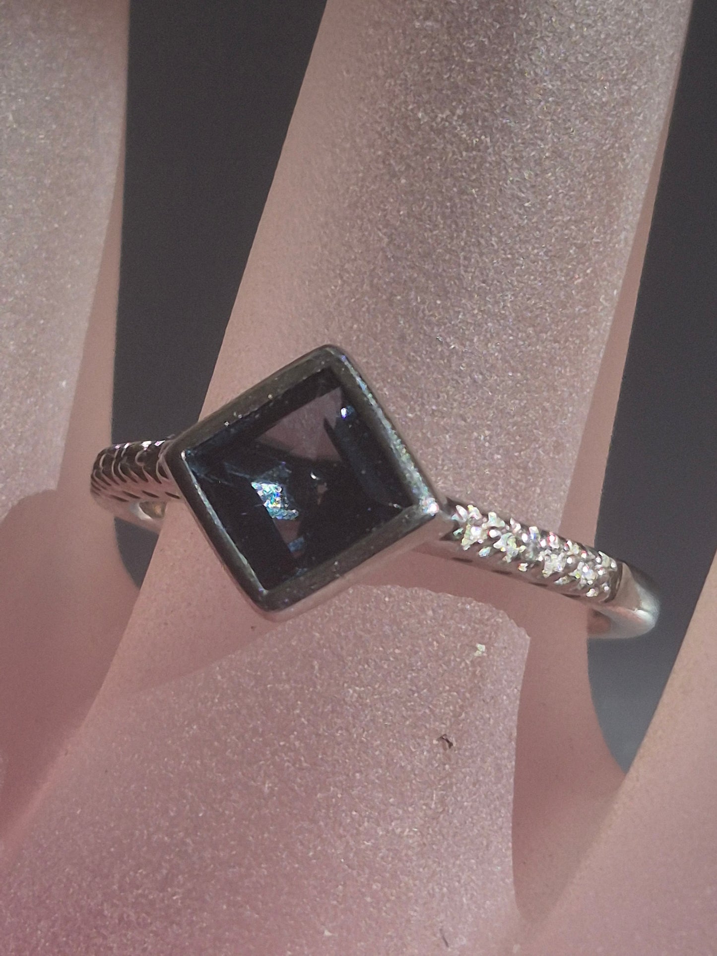 Square London Blue Topaz and diamond sterling silver ring worn on finger, front view showing the deep blue topaz and diamond side accents.
