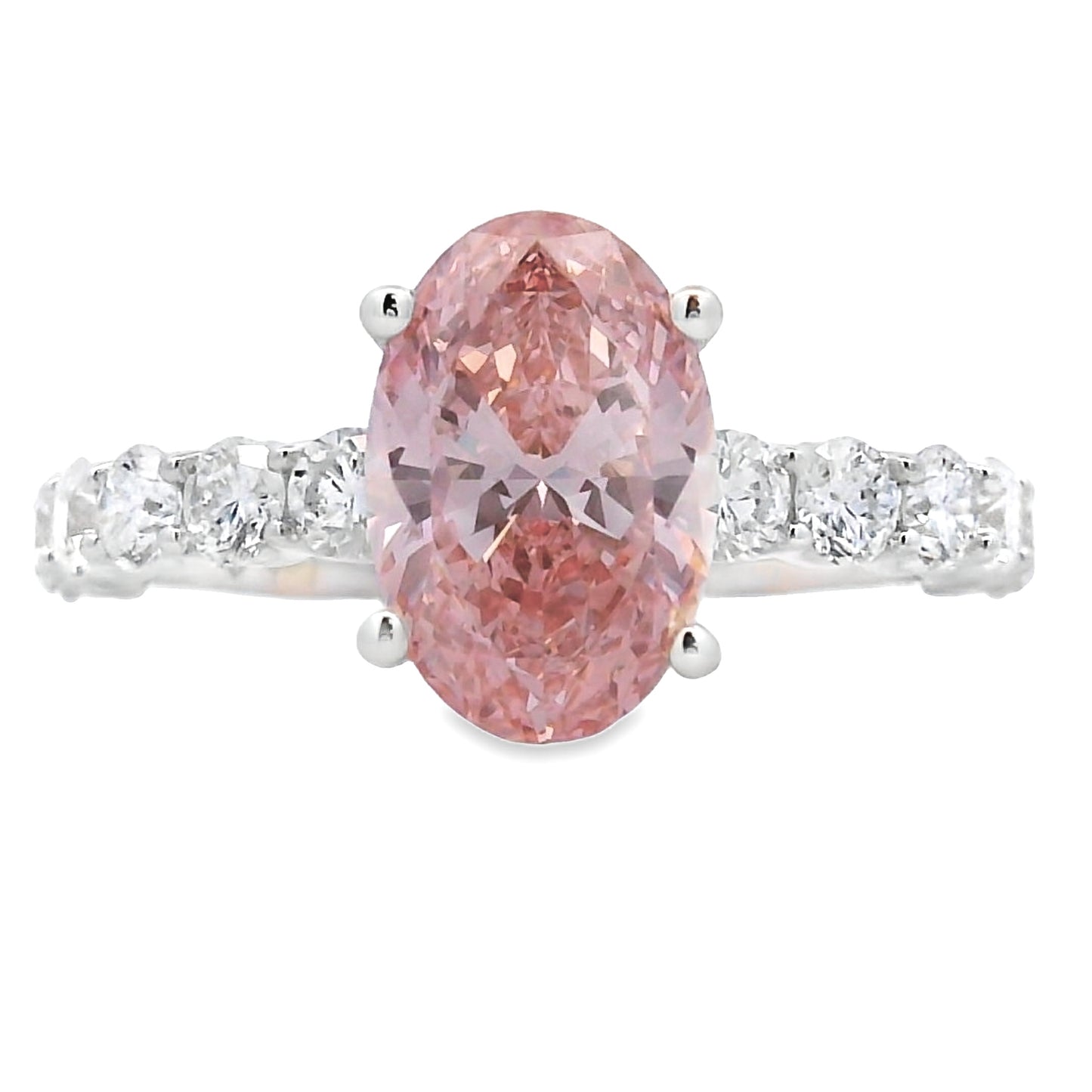 An oval-cut pink diamond ring set in a silver-colored band with small clear stones on either side, shown against a plain white background.