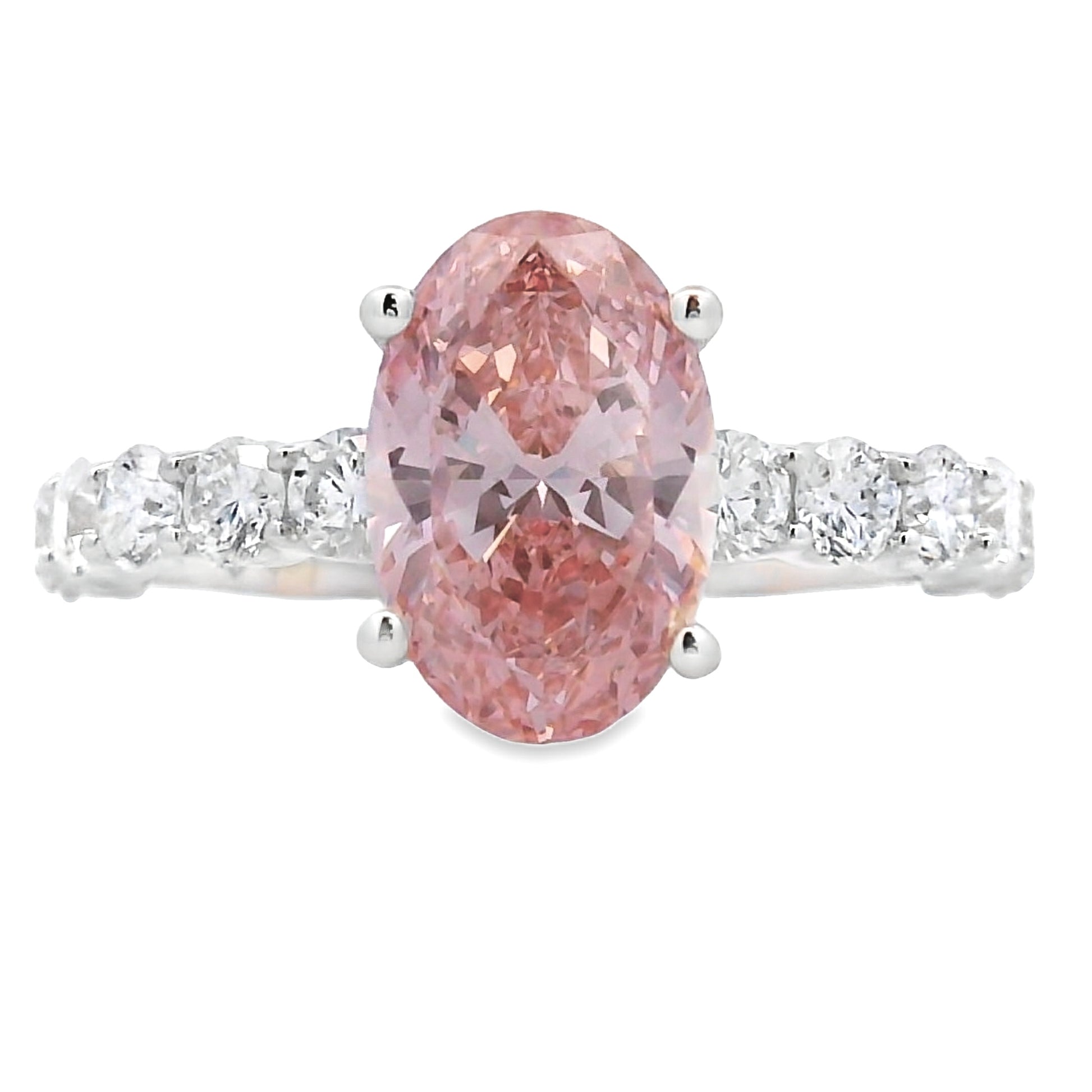 An oval-cut pink diamond ring set in a silver-colored band with small clear stones on either side, shown against a plain white background.