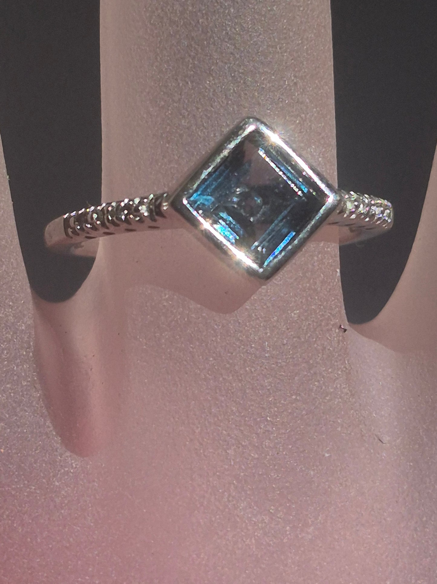 Square London Blue Topaz and diamond ring in sterling silver, shown on a ring display card, diagonal bezel setting with pavé diamond accents on the band.