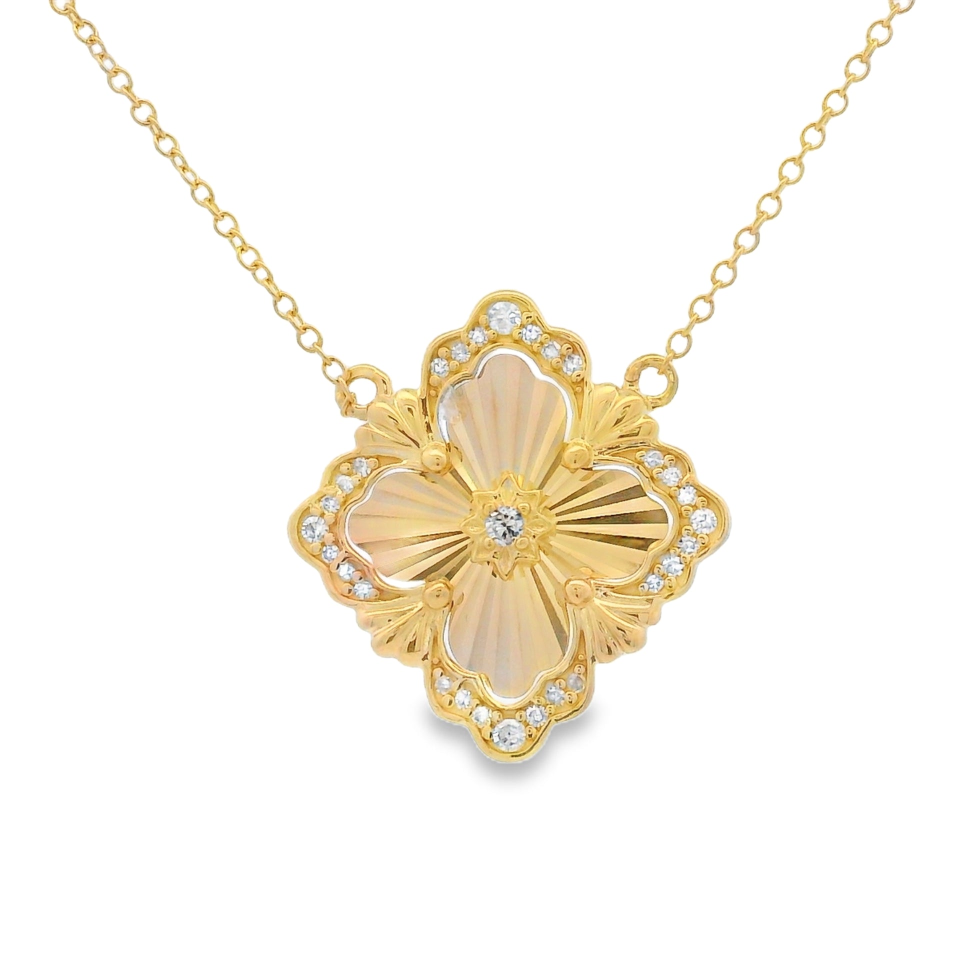 A gold-tone floral pendant necklace featuring a four-petal flower design with a central cabochon and small clear accent stones, suspended from a delicate gold chain on a white background.