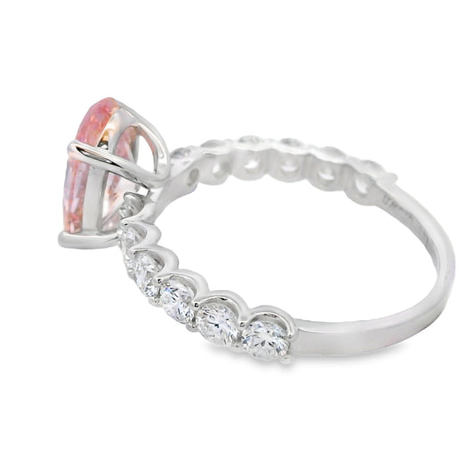 A silver-tone ring featuring a marquise-cut pink gemstone in a prong setting, with a row of small clear heart-shaped stones along the band, shown on a plain white background.